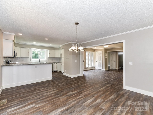 1117 Hidden Brook Ln, Clover, SC 29710 - kitchen with open floor plan, crown molding, dark wood-type flooring, a chandelier, and white cabinets