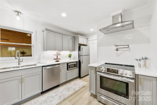 8438 Henry Harris Rd, Fort Mill, SC 29707 - kitchen featuring stainless steel appliances, wall chimney range hood, gray cabinets, decorative backsplash, and crown molding