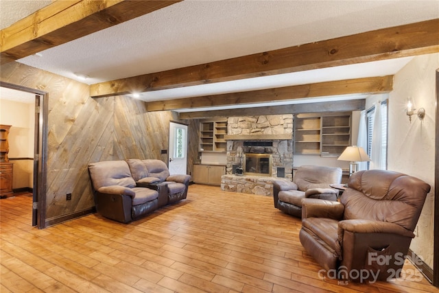 5563 Grace Chapel Rd, Hickory, NC 28601 - living area with beam ceiling, light wood-type flooring, a fireplace, a textured ceiling, and wood walls