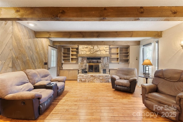 5563 Grace Chapel Rd, Hickory, NC 28601 - living room featuring light wood-style floors, beam ceiling, a stone fireplace, and built in features