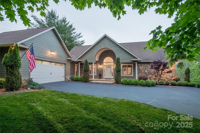 214 River Knoll Dr, Jefferson, NC 28640 - view of front of home featuring driveway, stone siding, a garage, a front lawn, and a shingled roof