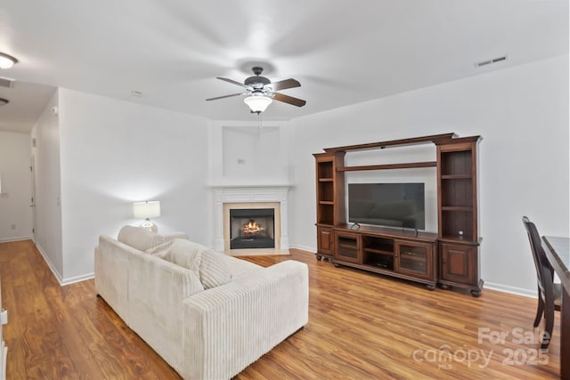 14664 Lions Paw St, Charlotte, NC 28273 - living area featuring a ceiling fan, a fireplace with flush hearth, and wood finished floors