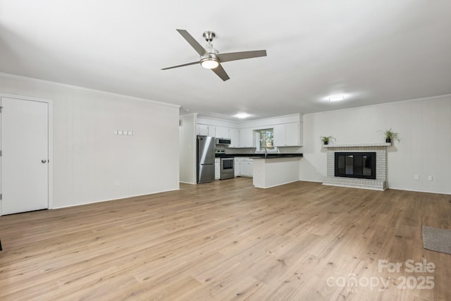 613 Davis St, Lancaster, SC 29720 - unfurnished living room with ceiling fan, light wood-type flooring, ornamental molding, and a fireplace
