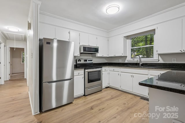613 Davis St, Lancaster, SC 29720 - kitchen featuring appliances with stainless steel finishes, crown molding, white cabinetry, light wood-type flooring, and dark stone counters