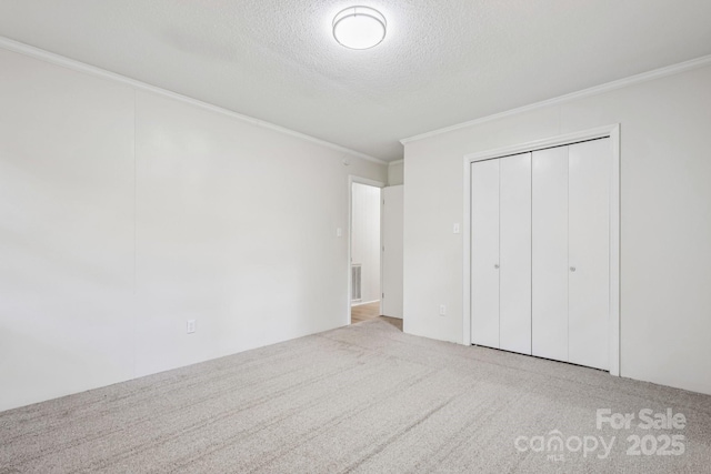 613 Davis St, Lancaster, SC 29720 - unfurnished bedroom featuring ornamental molding, carpet flooring, a textured ceiling, and a closet