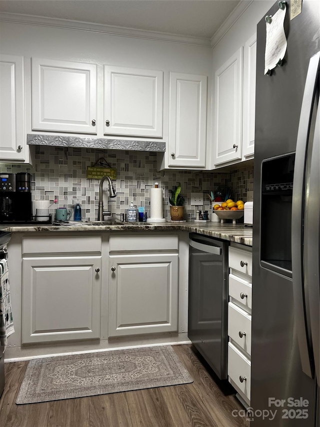 140 Lake Concord Rd NE, Concord, NC 28025 - kitchen featuring appliances with stainless steel finishes, white cabinetry, crown molding, dark wood-style flooring, and backsplash