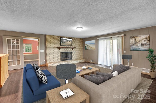 37156 Southside Rd, Albemarle, NC 28001 - living room with wood finished floors, a brick fireplace, and a textured ceiling