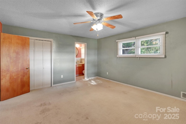 37156 Southside Rd, Albemarle, NC 28001 - unfurnished bedroom with carpet, a closet, ensuite bathroom, a ceiling fan, and a textured ceiling