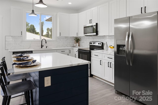 103 Wadesborough Pl, Wadesboro, NC 28170 - kitchen featuring stainless steel appliances, a breakfast bar, pendant lighting, tasteful backsplash, and white cabinets