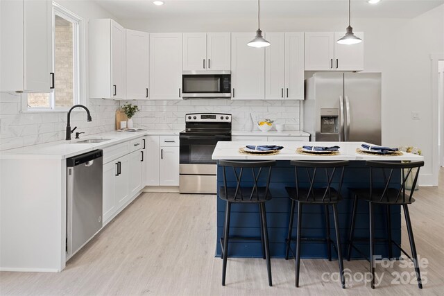103 Wadesborough Pl, Wadesboro, NC 28170 - kitchen with appliances with stainless steel finishes, a kitchen island, a breakfast bar, light countertops, and light wood-type flooring