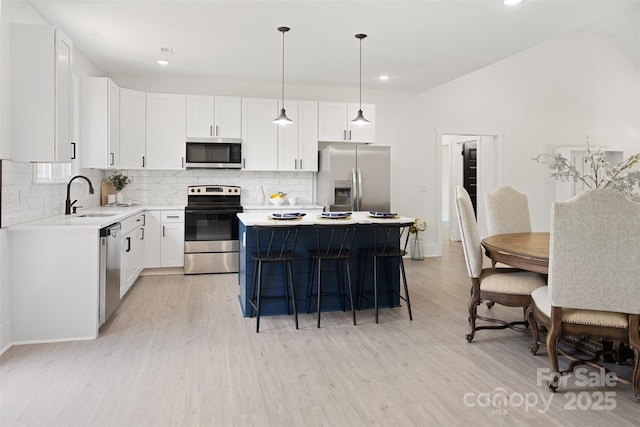 103 Wadesborough Pl, Wadesboro, NC 28170 - kitchen featuring stainless steel appliances, light wood-type flooring, tasteful backsplash, a breakfast bar, and recessed lighting