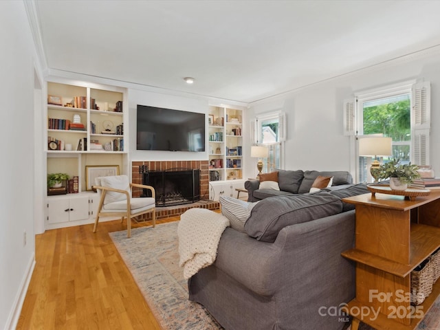6934 Loretta Pl, Charlotte, NC 28215 - living area with a fireplace, light wood-style floors, built in shelves, and crown molding