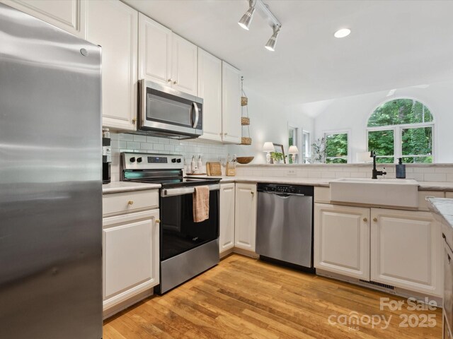 6934 Loretta Pl, Charlotte, NC 28215 - kitchen featuring appliances with stainless steel finishes, white cabinetry, backsplash, light countertops, and recessed lighting