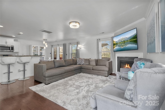 3735 Ernie Dr, Charlotte, NC 28269 - living area featuring dark wood-style floors, ornamental molding, a lit fireplace, and recessed lighting