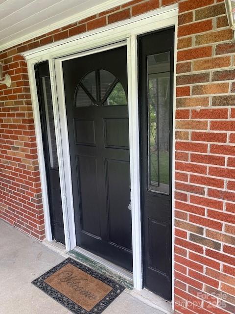 entrance to property featuring brick siding