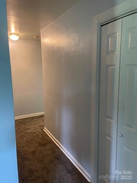 hall featuring carpet floors and baseboards