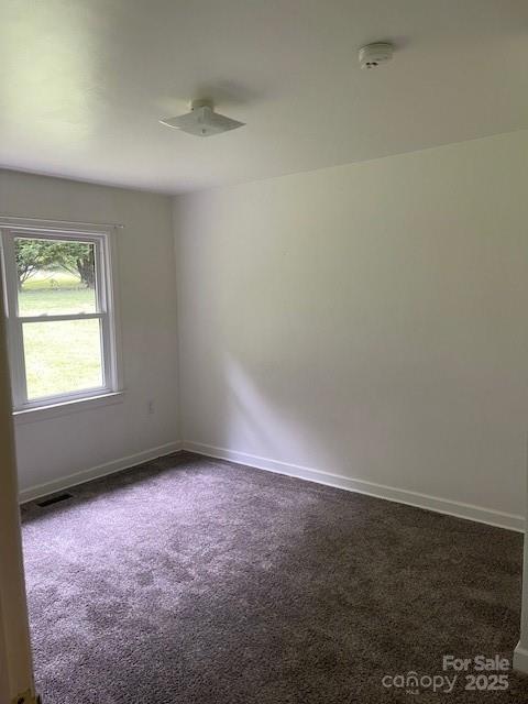 empty room with carpet floors and a smoke detector