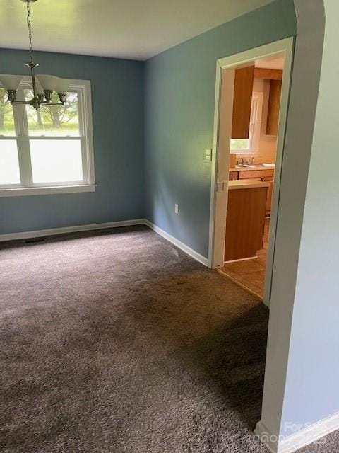 carpeted empty room featuring baseboards