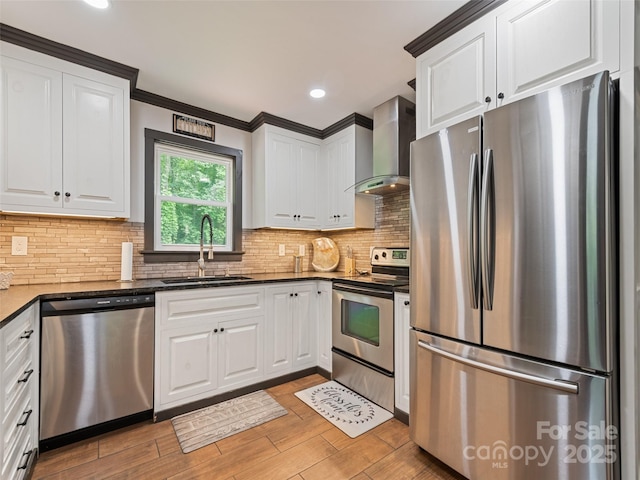 229 Yellow Bird Branch Rd, Sylva, NC 28779 - kitchen featuring appliances with stainless steel finishes, wall chimney range hood, white cabinets, ornamental molding, and recessed lighting