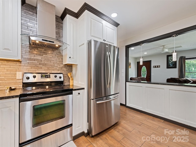229 Yellow Bird Branch Rd, Sylva, NC 28779 - kitchen with stainless steel appliances, wall chimney range hood, dark countertops, tasteful backsplash, and white cabinets