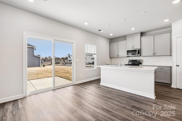 2125 Rolling Hills Ct, Stanley, NC 28164 - kitchen featuring stainless steel microwave, gray cabinets, electric range oven, dark wood-style floors, and backsplash