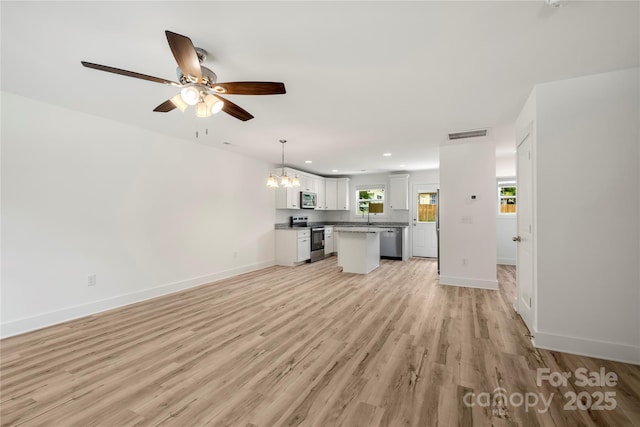 443 Faith Dr SW, Concord, NC 28027 - unfurnished living room with a chandelier, light wood-style flooring, recessed lighting, and a ceiling fan