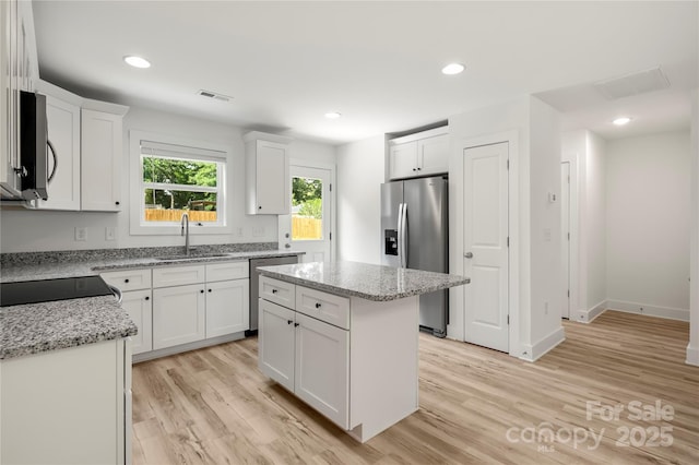 443 Faith Dr SW, Concord, NC 28027 - kitchen with appliances with stainless steel finishes, light wood-type flooring, white cabinetry, a center island, and recessed lighting