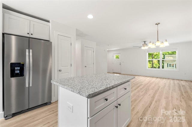 443 Faith Dr SW, Concord, NC 28027 - kitchen featuring stainless steel refrigerator with ice dispenser, light wood-style flooring, a kitchen island, white cabinetry, and light stone countertops