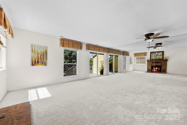 1670 Robins Nest Ct Unit D, Gastonia, NC 28054 - unfurnished living room with a warm lit fireplace, carpet, ceiling fan, and a textured ceiling