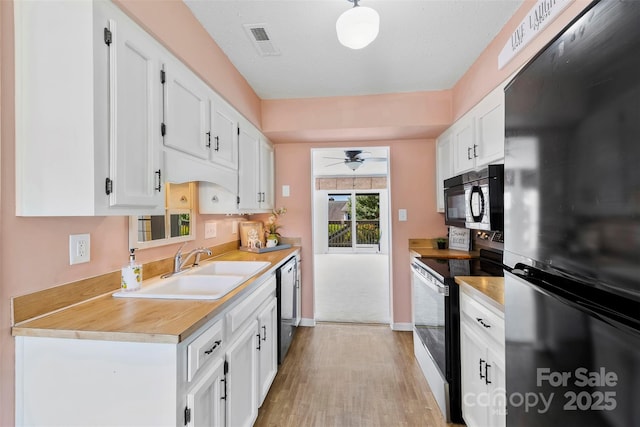1670 Robins Nest Ct Unit D, Gastonia, NC 28054 - kitchen featuring freestanding refrigerator, electric range, black microwave, light wood-style floors, and white cabinetry