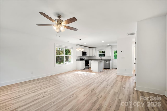 445 Faith Dr SW, Concord, NC 28027 - unfurnished living room with a chandelier, a ceiling fan, light wood-type flooring, and recessed lighting
