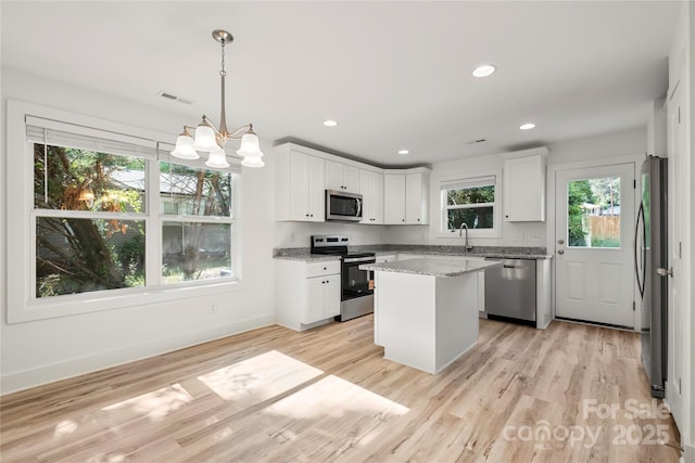 445 Faith Dr SW, Concord, NC 28027 - kitchen with stainless steel appliances, white cabinetry, a chandelier, light wood-style floors, and recessed lighting
