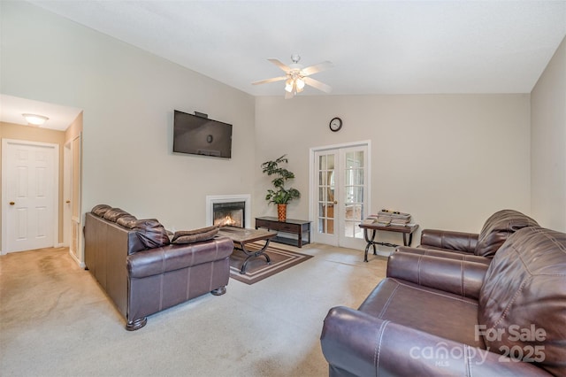 8119 Tremaine Ct Unit E, Charlotte, NC 28227 - living room featuring light colored carpet, ceiling fan, french doors, a glass covered fireplace, and vaulted ceiling