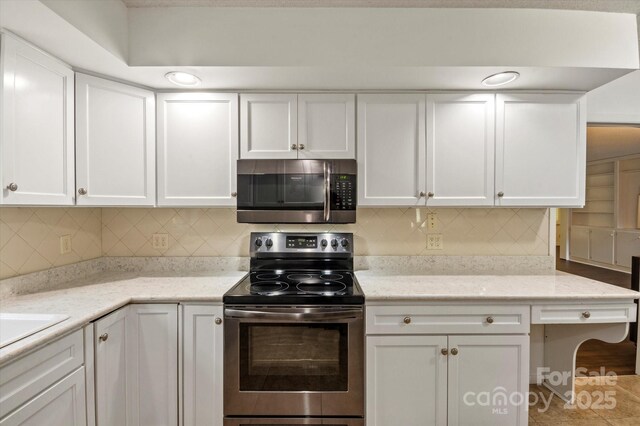 55 Diamond Ridge Ln, Columbus, NC 28722 - kitchen with appliances with stainless steel finishes, white cabinetry, decorative backsplash, and light stone counters