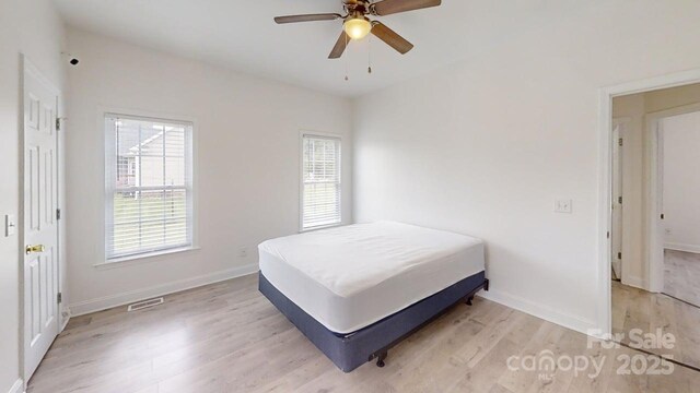 6825 Woodleaf Rd, Woodleaf, NC 27054 - bedroom with light wood-type flooring, multiple windows, and ceiling fan