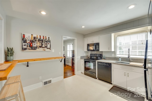 7026 Tabor Ln, Charlotte, NC 28211 - kitchen featuring black appliances, plenty of natural light, white cabinets, and recessed lighting