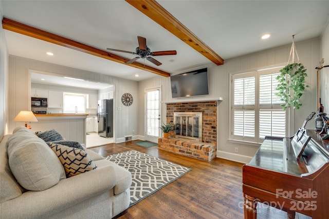 7026 Tabor Ln, Charlotte, NC 28211 - living room featuring dark wood-style flooring, a ceiling fan, beam ceiling, a fireplace, and recessed lighting