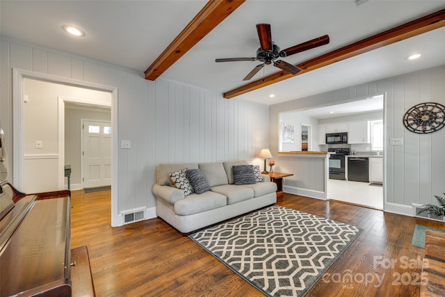 7026 Tabor Ln, Charlotte, NC 28211 - living room featuring wood finished floors, a ceiling fan, beamed ceiling, healthy amount of natural light, and a decorative wall