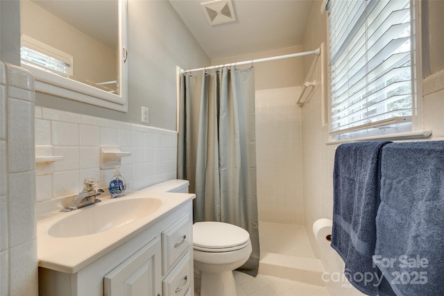 7026 Tabor Ln, Charlotte, NC 28211 - full bath with tile walls, tiled shower, plenty of natural light, vanity, and tile patterned floors