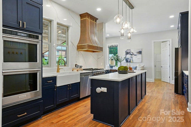 7903 Tottenham Ct, Waxhaw, NC 28173 - kitchen with appliances with stainless steel finishes, custom range hood, light countertops, light wood finished floors, and recessed lighting