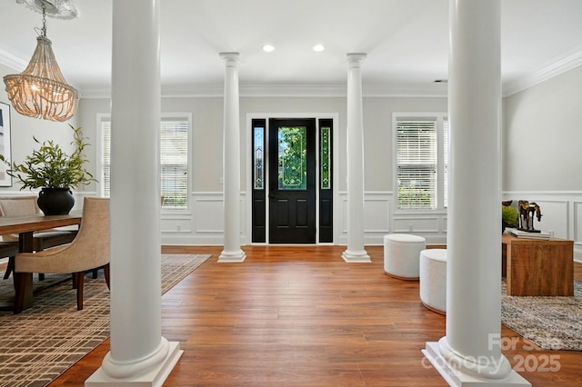 7903 Tottenham Ct, Waxhaw, NC 28173 - entrance foyer featuring a decorative wall, crown molding, a wainscoted wall, ornate columns, and wood finished floors