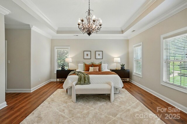 7903 Tottenham Ct, Waxhaw, NC 28173 - bedroom with wood finished floors, a chandelier, a tray ceiling, and crown molding