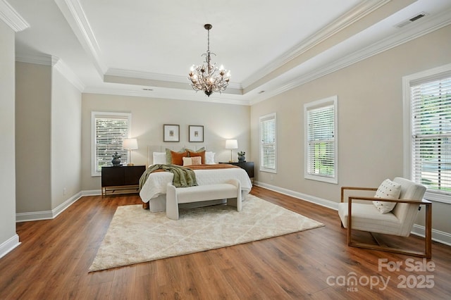 7903 Tottenham Ct, Waxhaw, NC 28173 - bedroom with wood finished floors, a chandelier, ornamental molding, and a tray ceiling