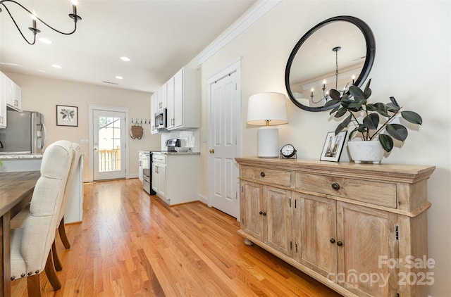 7344 Gilead Rd, Huntersville, NC 28078 - kitchen featuring appliances with stainless steel finishes, a chandelier, light countertops, light wood-style flooring, and recessed lighting