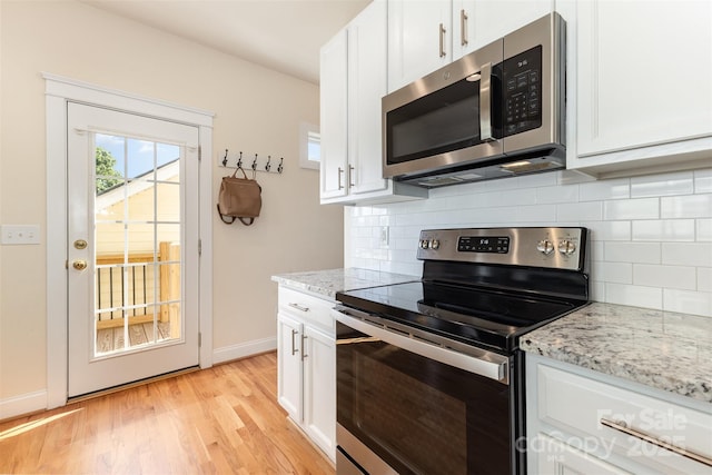 7344 Gilead Rd, Huntersville, NC 28078 - kitchen featuring stainless steel appliances, light wood finished floors, backsplash, and white cabinets