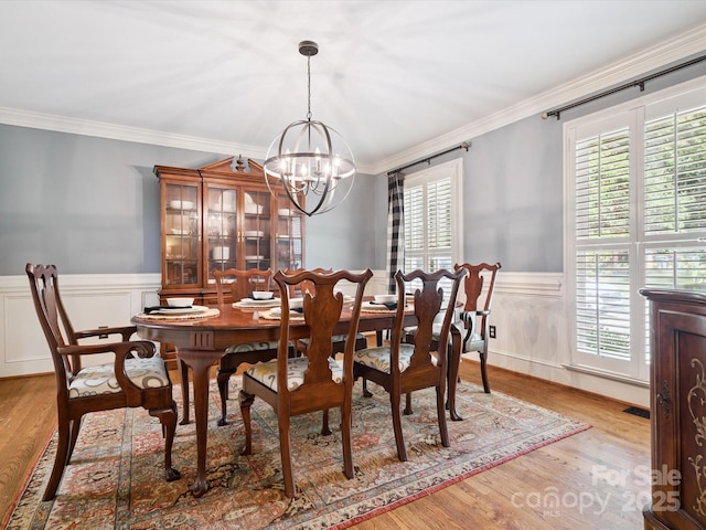 2032 Greenbrook Pkwy, Matthews, NC 28104 - dining room with a chandelier, plenty of natural light, a wainscoted wall, ornamental molding, and wood finished floors