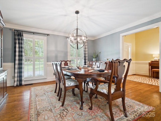 2032 Greenbrook Pkwy, Matthews, NC 28104 - dining space featuring a chandelier, ornamental molding, light wood finished floors, wainscoting, and a decorative wall