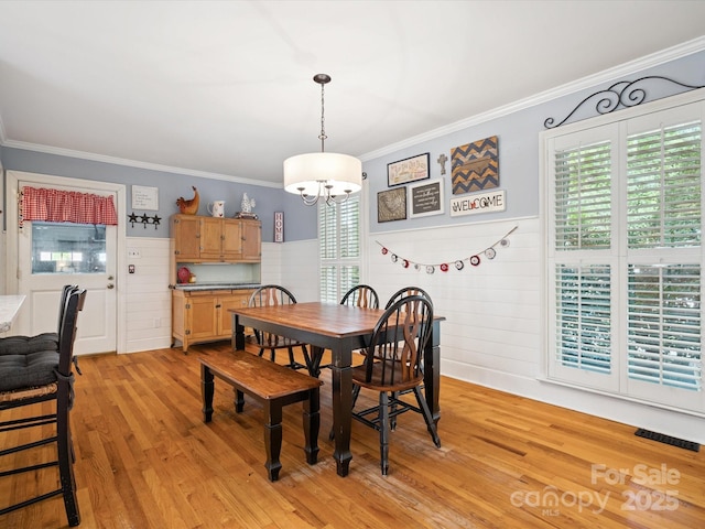 2032 Greenbrook Pkwy, Matthews, NC 28104 - dining area featuring a chandelier, crown molding, light wood-type flooring, and wainscoting