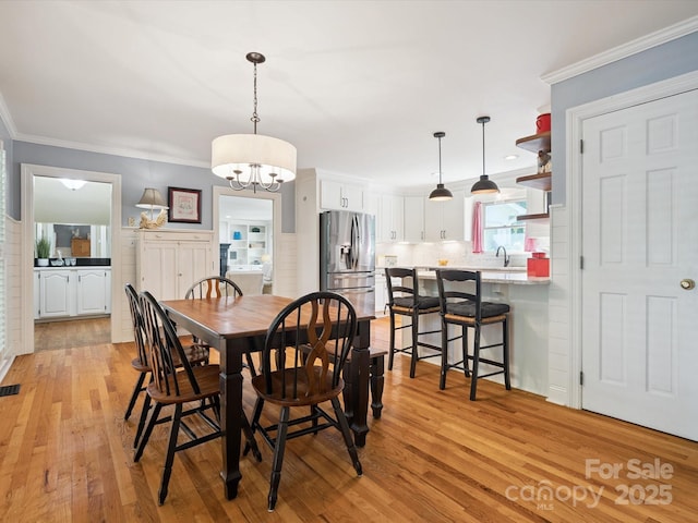2032 Greenbrook Pkwy, Matthews, NC 28104 - dining room featuring light wood-type flooring, crown molding, and a chandelier