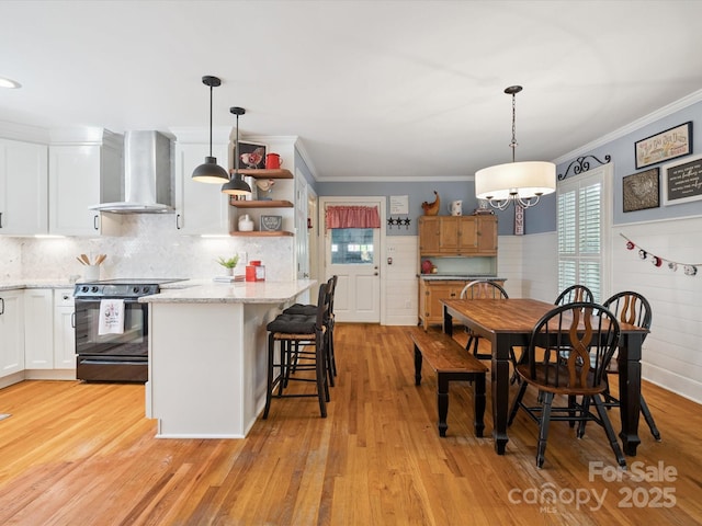 2032 Greenbrook Pkwy, Matthews, NC 28104 - kitchen featuring wall chimney exhaust hood, electric range, ornamental molding, light wood finished floors, and white cabinetry